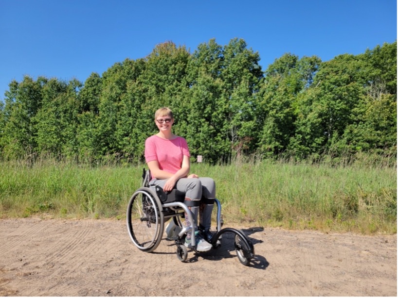 Charlotte with the FreeWheel Wheelchair Attachment—an off-roading attachment for an individual’s personal manual wheelchair.